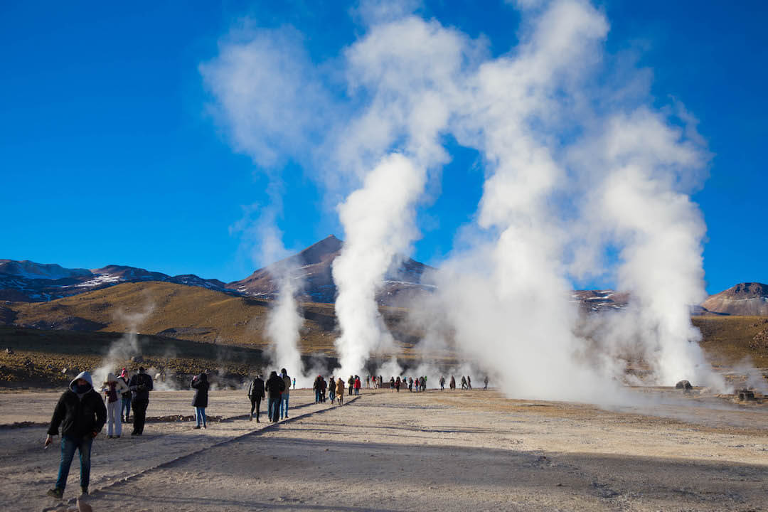 Turistas y geysers bajo un cielo despejado