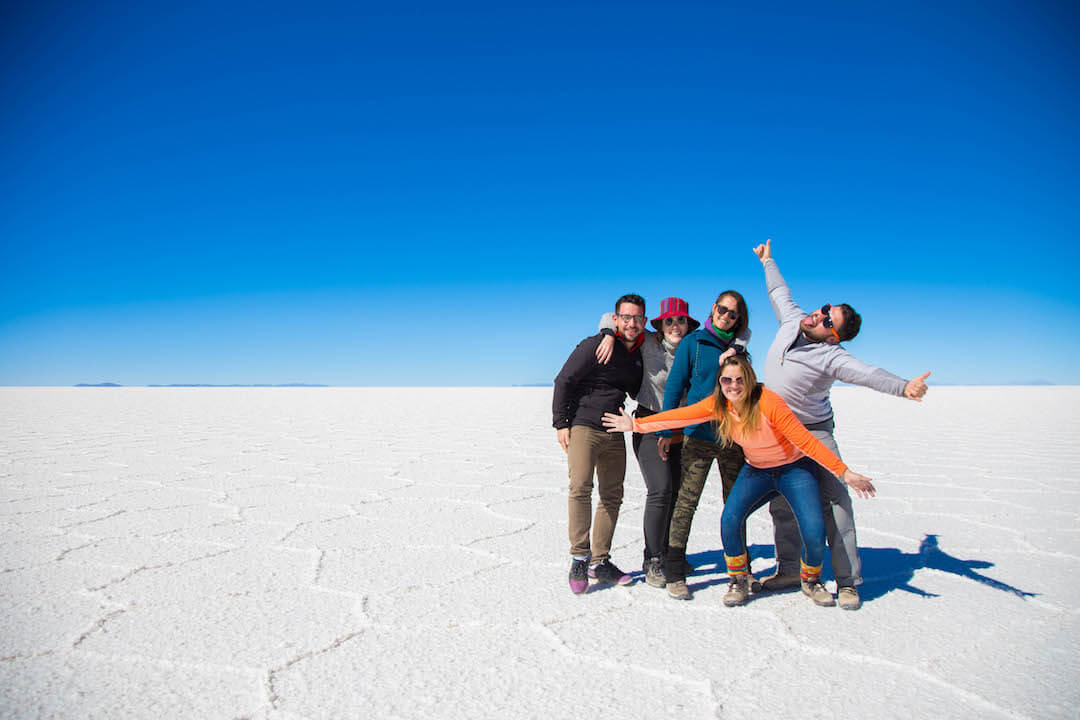 Grupo de turistas posan sobre salar blanco en Uyuni
